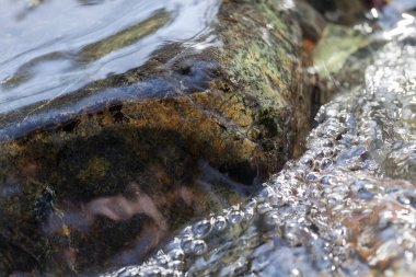 Berrak dağ suyundaki kayalar, yüzeysel alan derinliğine dikkat edin.