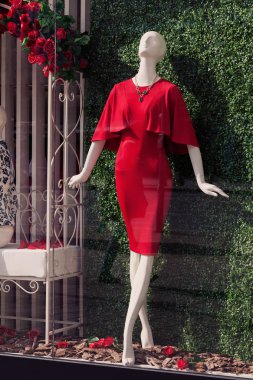 Mağaza vitrininde kırmızı elbiseli bir bebek, sığ alan derinliğine dikkat edin.