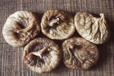 dried figs on a wooden table, note shallow depth of field