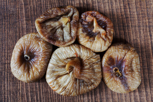dried figs on a wooden table, note shallow depth of field