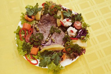 beef steak decorated with lots of vegetables