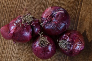 red onions on a  wooden board, note shallow depth of field
