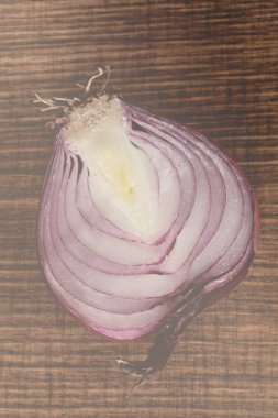 half of red onion on a  wooden board, note shallow depth of field