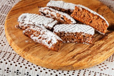 Tahtaya toz şeker serpiştirilmiş elmalı turta parçaları, sığ alan derinliğine dikkat edin.