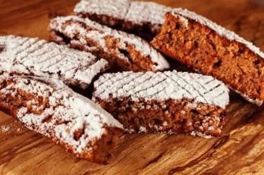 Tahtaya toz şeker serpiştirilmiş elmalı turta parçaları, sığ alan derinliğine dikkat edin.