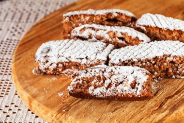 Tahtaya toz şeker serpiştirilmiş elmalı turta parçaları, sığ alan derinliğine dikkat edin.