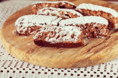 Tahtaya toz şeker serpiştirilmiş elmalı turta parçaları, sığ alan derinliğine dikkat edin.