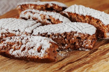Tahtaya toz şeker serpiştirilmiş elmalı turta parçaları, sığ alan derinliğine dikkat edin.