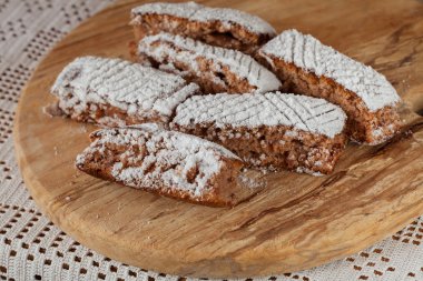 Tahtaya toz şeker serpiştirilmiş elmalı turta parçaları, sığ alan derinliğine dikkat edin.