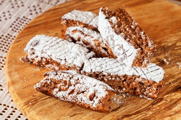 Tahtaya toz şeker serpiştirilmiş elmalı turta parçaları, sığ alan derinliğine dikkat edin.