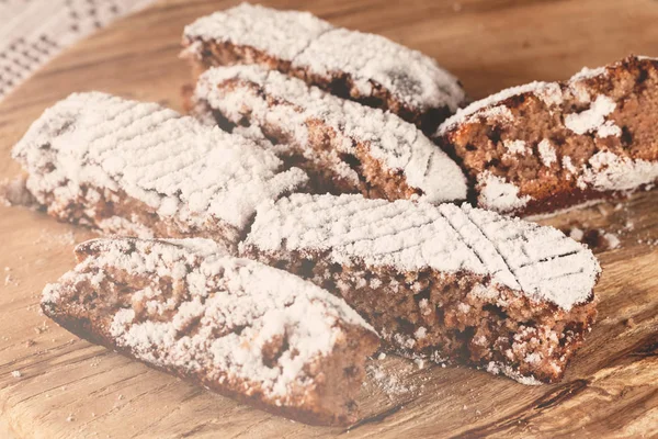 Tahtaya toz şeker serpiştirilmiş elmalı turta parçaları, sığ alan derinliğine dikkat edin.