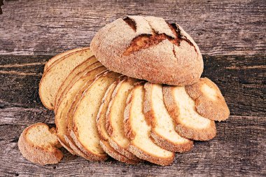 Round corn bread and slices of corn bread on the wooden board, note shallow depth of field