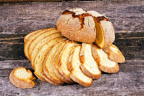 Round corn bread and slices of corn bread on the wooden board, note shallow depth of field