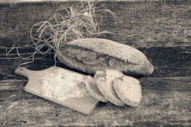 Çavdar ekmeği, kurutulmuş otlar ve un ile ahşap bir tabanda süsleme