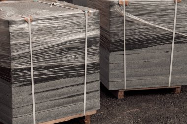 Tahta palette folyoya sarılı karmaşık granit levhalar, sığ alan derinliğine dikkat edin.