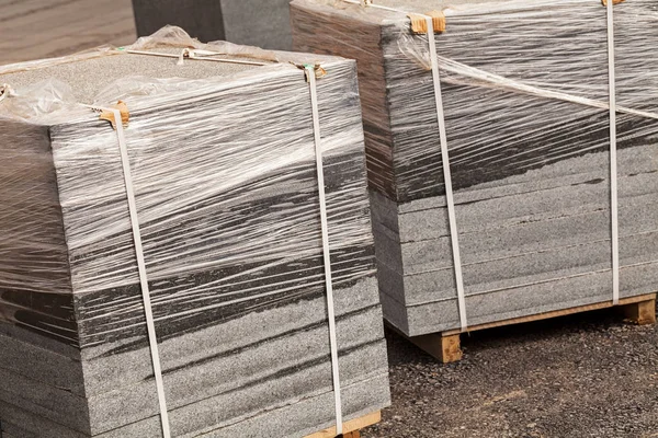 Tahta palette folyoya sarılı karmaşık granit levhalar, sığ alan derinliğine dikkat edin.