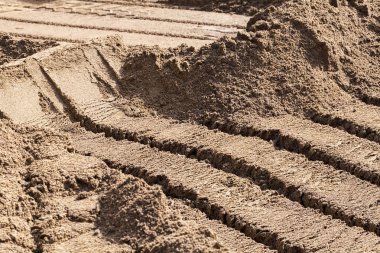 Kazı makinesine yüklemek için kova izleri olan kumlar inşa ediliyor.