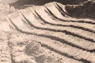 Kazı makinesine yüklemek için kova izleri olan kumlar inşa ediliyor.