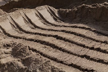 Kazı makinesine yüklemek için kova izleri olan kumlar inşa ediliyor.