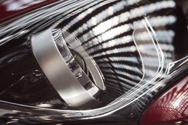 type  of headlights on the red car, note shallow depth of field