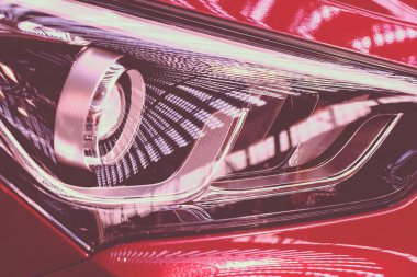 type  of headlights on the red car, note shallow depth of field