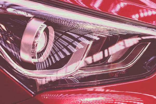 type  of headlights on the red car, note shallow depth of field