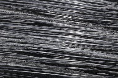 Çimentoya şeffaf naylon döküyor.