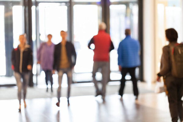 silhouettes of people as they move through the mal with light backgroundl, for the bluured background