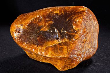 Değerli taş, siyah arka planda kehribar.