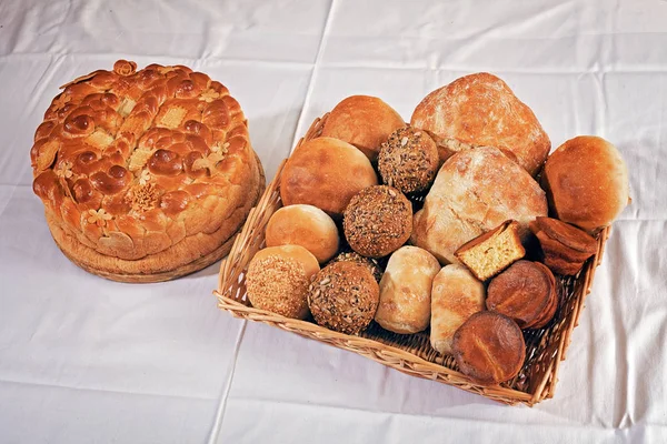 various kinds of bread  made from various flour in  a wicker basket next Slava cake