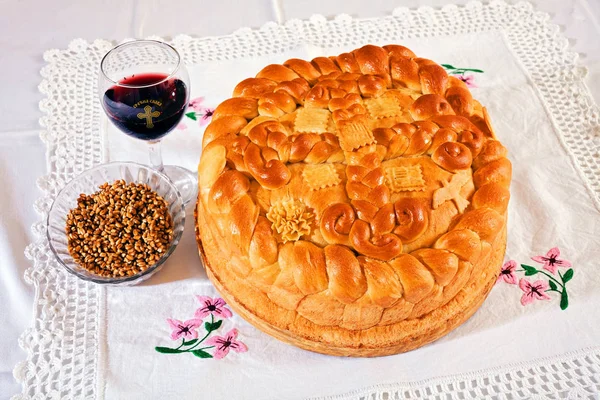 Geleneksel ortodoks pastası. Bir bardak kırmızı şarap ve dantel kumaşın üzerinde tahıl.