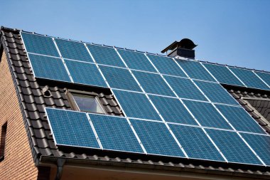 Çatı katı güneş paneli sistemine yerleştirilmiş. Çatı yüzeyi güneş toplayıcılarıyla kaplı. Güneş panelleri ile donatılmış tuğla ev bir barınağa güç veriyor. Elektrik üretmek için güneş enerjisi.