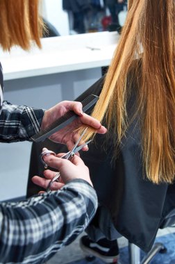 Kuaför saç modeli keser. Saç kesme. Güzellik Salonu bir saç kesimi. Bir stüdyoda kesim saç işlemidir. Kuaför makası ve tarak ile çalışıyor. Kadın sarışın saçlarını yapıyor.
