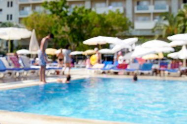 Görüntü'nün birçok kişi bir sıcak yaz gününde havuz kenarında dinlenin. Tatil, tatil sırasında mükemmel rahatlama güneyde. Erkekler, kadınlar, çocuklar yüzme havuzunda ve şezlonglar üzerinde güneşlenmek.