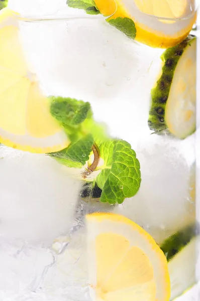 The main drink for detoxifying the body close-up. Alcoholic, nonalcoholic drink with cucumber, mint, lemon, ice cubes. Ice mojito with water or tonic. Morning drink for intensive weight loss. — Stock Photo, Image