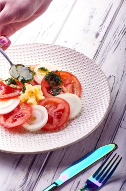 Bir kadın aşçı sebze, zeytin, ayçiçeği, mısır yağı ve maydanoz, kişniş, fesleğen üzerinden güzel bir salata sosu dökülen. Yemek sağlıklı diyet Kahvaltı, Öğle Yemeği, akşam yemeği.