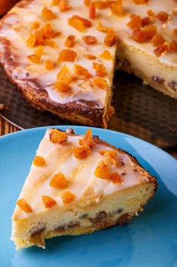 Peynirli kek lezzetli bir tatlı olarak seçeneklerden biri. Lehçe Cracow peynirli kek. İştah açıcı syrnik Kuruyemiş ve portakal ile. Çocuklar ve yetişkinler sıcak turuncu tonları için a muamele etmek.