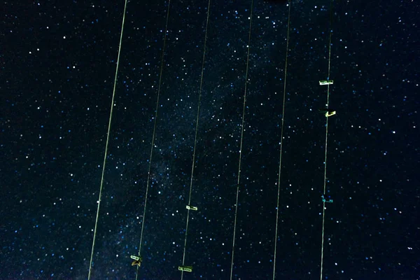 Uma vista de baixo no céu estrelado da noite e a maneira leitosa através do secador de roupas em que os clothespins penduram — Fotografia de Stock