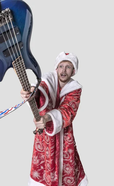 Jovem na imagem de Papai Noel com uma guitarra — Fotografia de Stock
