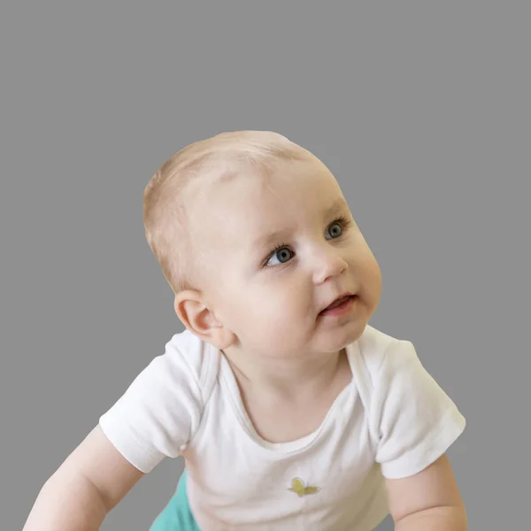 Мила маленька дитина виглядає з інтересом і злегка відкритим ротом, ізольована на сірому фоні . — стокове фото
