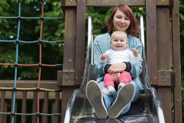 Junge Mutter verbringt gerne Zeit mit einem kleinen Kind in einem Sommerpark. — Stockfoto