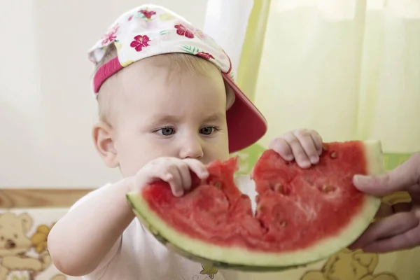 Aktív aranyos baba érzelmileg a telken egy görögdinnye. — Stock Fotó