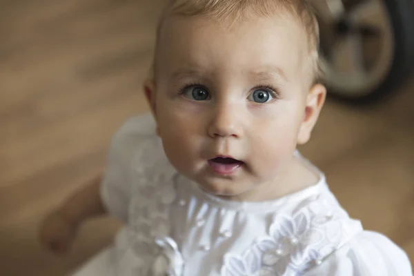 Kis aranyos baba kék szemmel és nyitott szájjal nézi a kamerát. — Stock Fotó