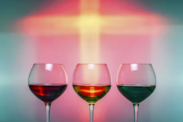 Three glasses with colorful drinks on a colorful festive background