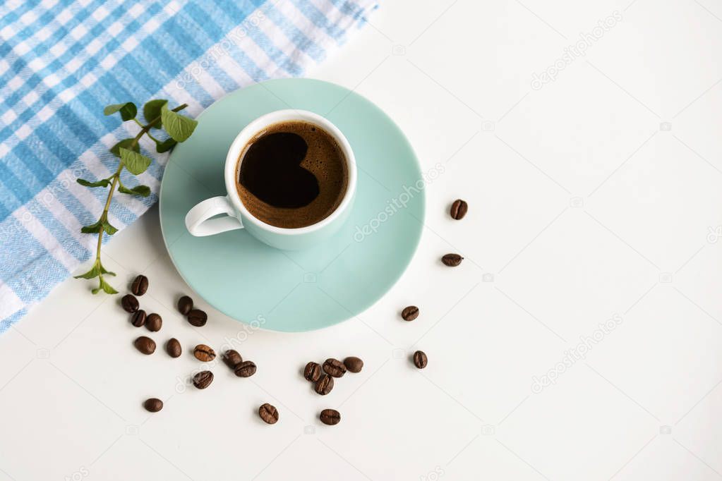 Strong black coffee in a light blue cup on a white table