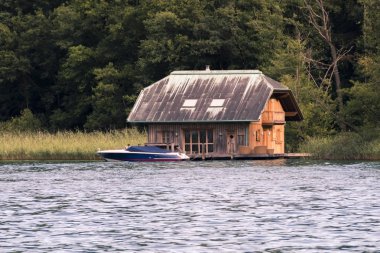 Açık veranda ve tekne ile göl kenarında ahşap ev