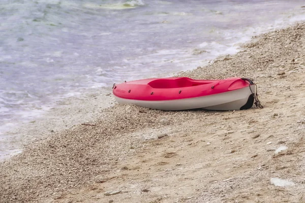 Red and white canoe on sandy beach, copyspace, nobody