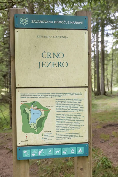 Природний заповідник Crno jezero (Чорне озеро) знак, Похор'є, Словенія — стокове фото