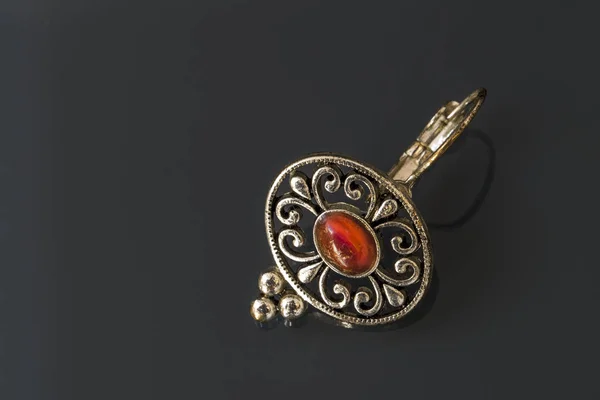 Silver earrings with red gems on dark background with reflection — Stock Photo, Image