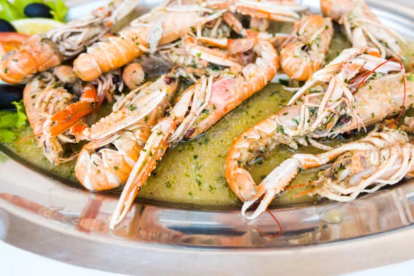 Cooked Scampi Prawns Shrimps in white wine sauce with garlic and parsley, closeup, isolated
